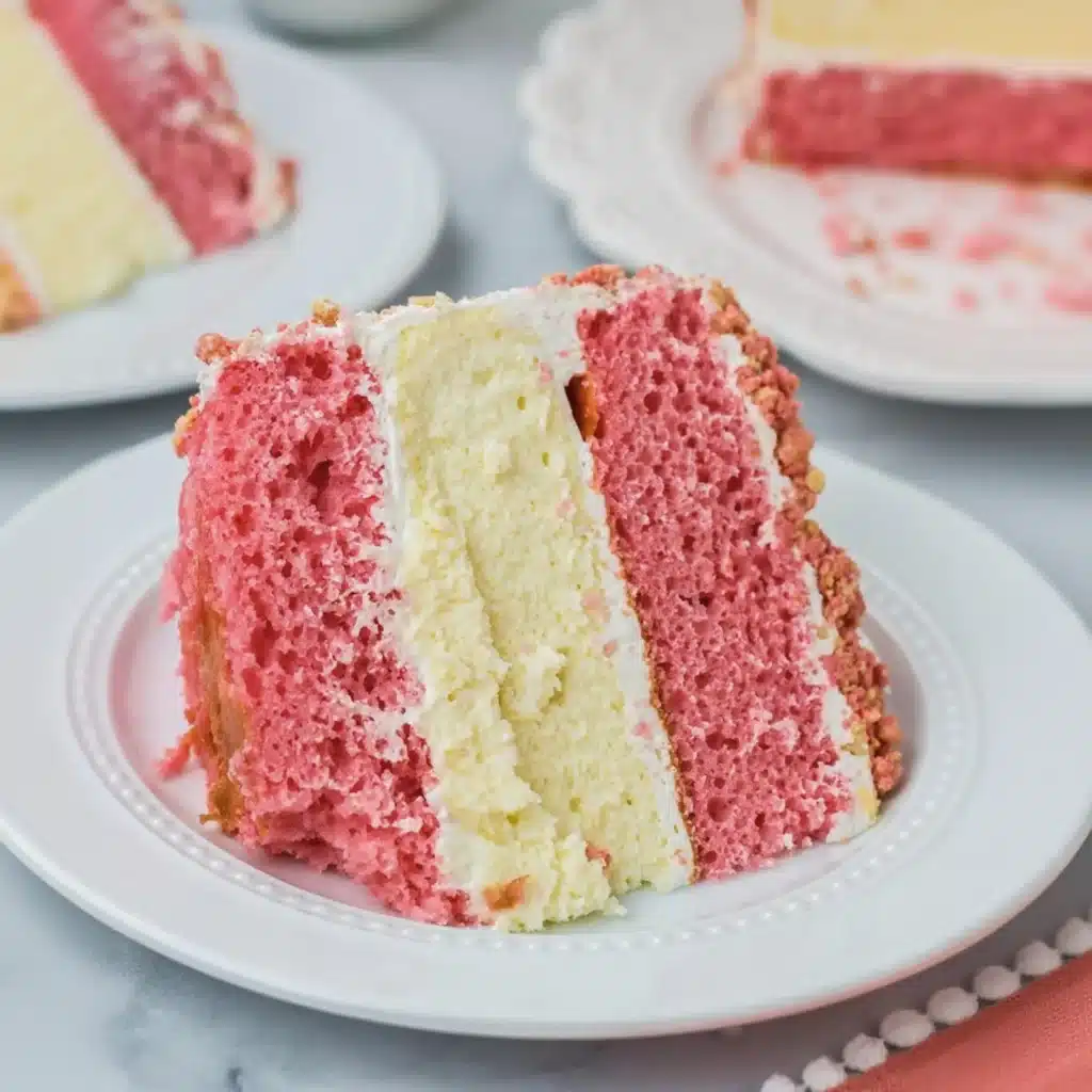 slice of strawberry cake and cheesecake with golden crumble on a white plate