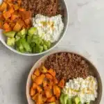 Two healthy beef bowls with avocado and sweet potato