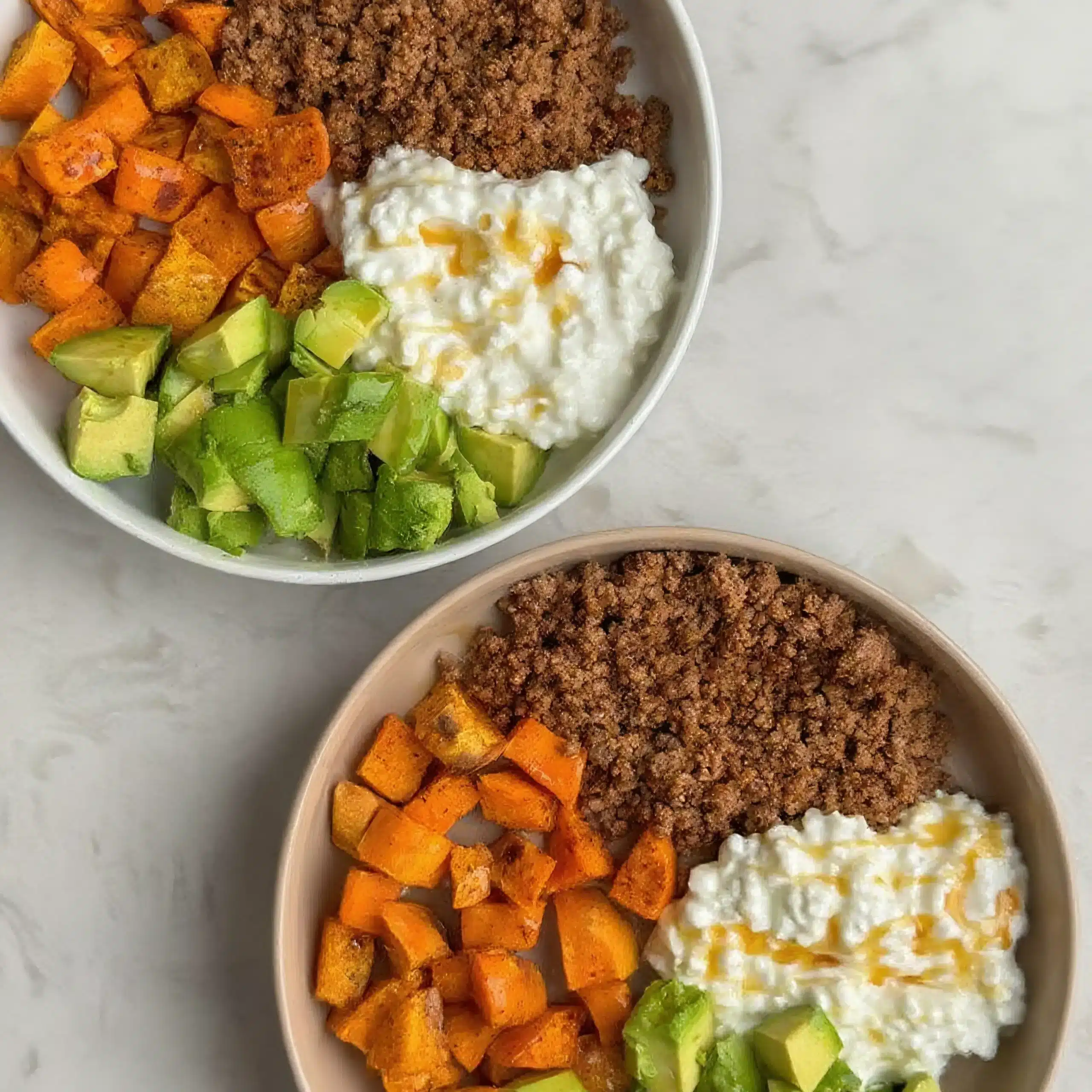 Two healthy beef bowls with avocado and sweet potato