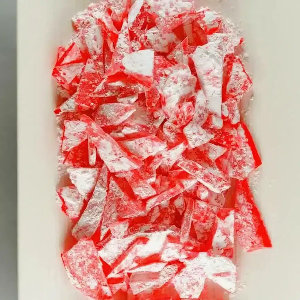 Rock Candy Recipe That Turns Sugar Into Sparkling Magic 2 Broken red rock candy recipe shards dusted with powdered sugar on a tray
