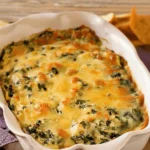 Baked olive garden artichoke and spinach dip fresh out of the oven with golden melted cheese.