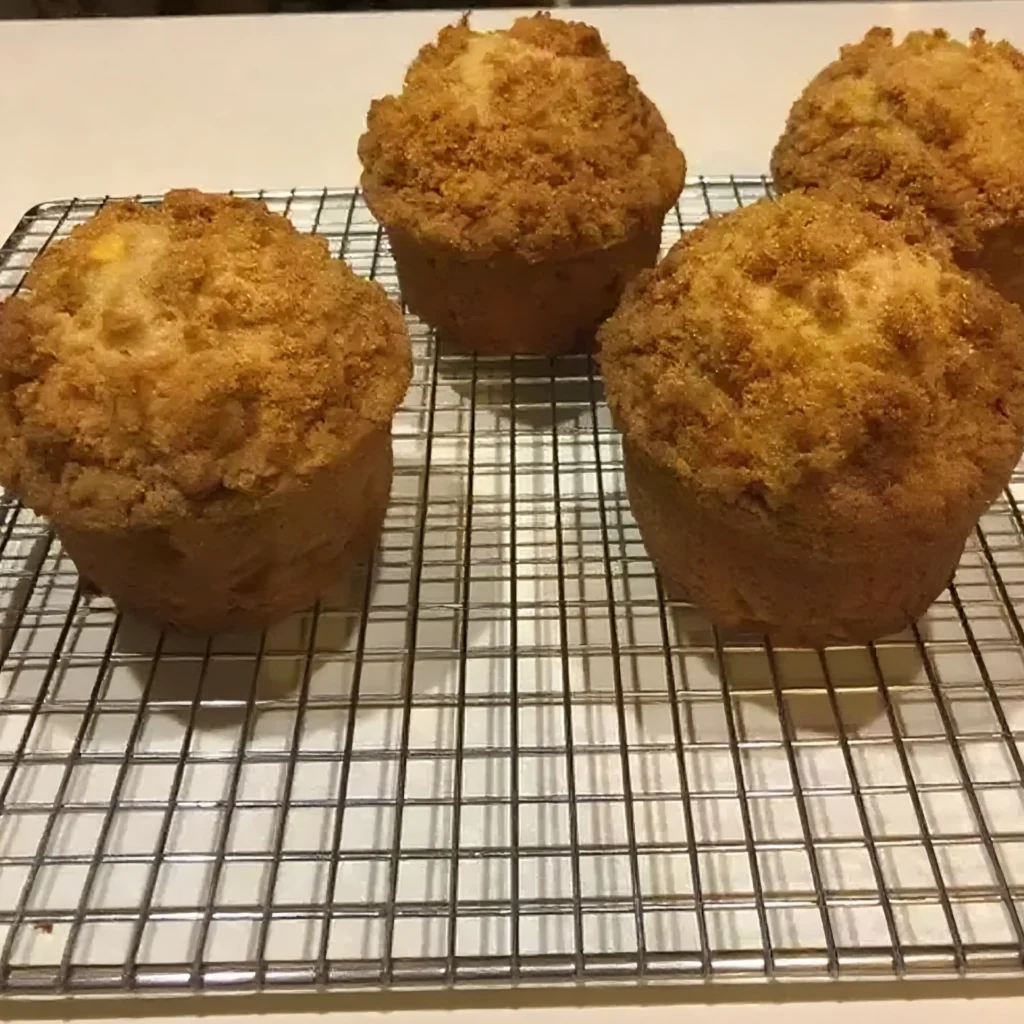 Apple Cinnamon Muffins Recipe 5 Freshly baked apple cinnamon muffins with crumb topping cooling on a wire rack.